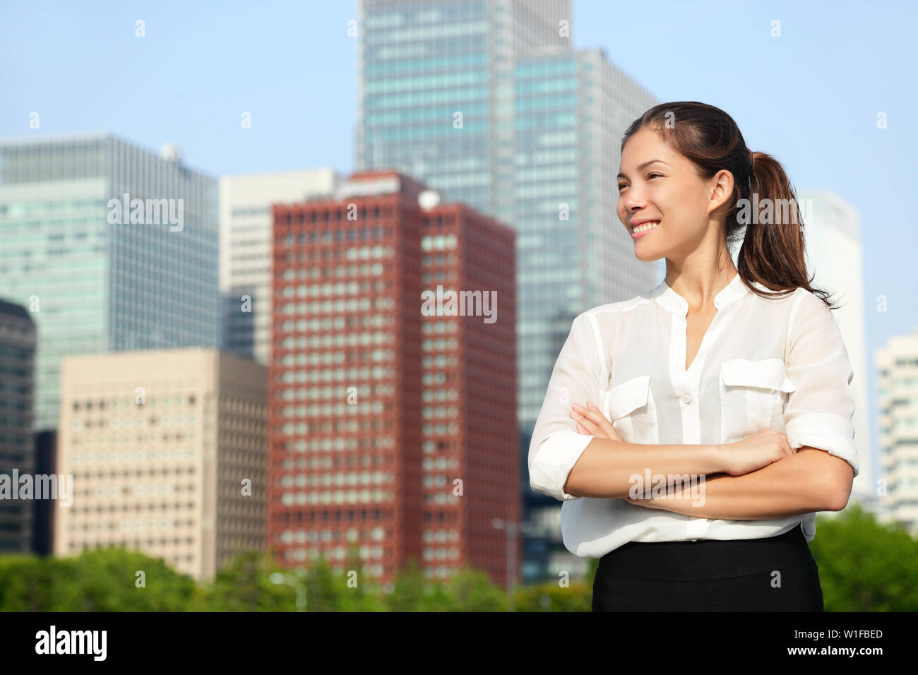 Asiatische Geschäftsfrau portrait in Tokio. Happy selbstbewussten jungen smart Professional im casual Business Outfit in der japanischen Downtown Tokyo mit Skyline im Hintergrund. Stockfoto