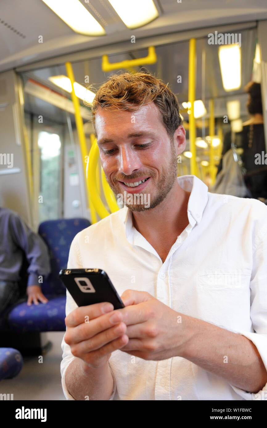U-Bahn Geschäftsmann sms sms über Smartphone Apps. Legerer mann Lesen von E-Mails oder Nachrichten auf Smart Phone online durch 3 g oder 4 g mit Wifi auf schwedische U-Bahn oder im Zug in Stockholm, Schweden. Stockfoto