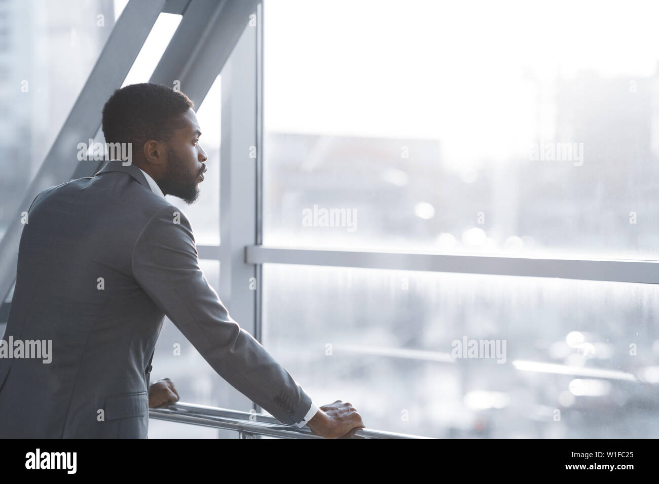 Für Flug warten. Afro Geschäftsmann auf der Suche Durch das Fenster Stockfoto