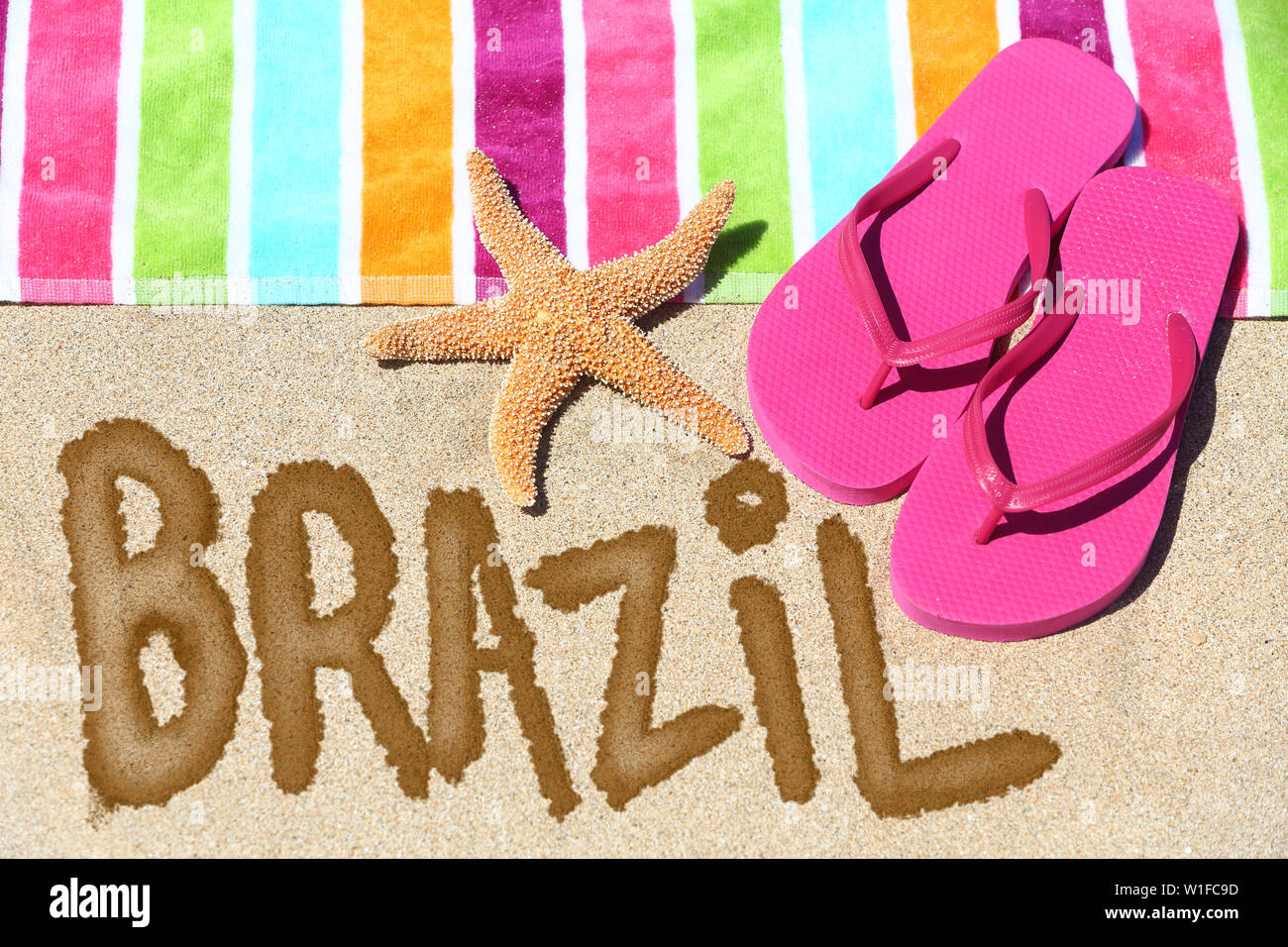 Brasilien Konzept. Ansicht von oben ot das Wort Brasilien am Strand Sand mit einem bunt gestreiften Handtuch geschrieben, pink Tangas und ein Seestern konzeptionelle eines Sommer Urlaub und Reisen in Rio de Janiero, Brasilien. Stockfoto