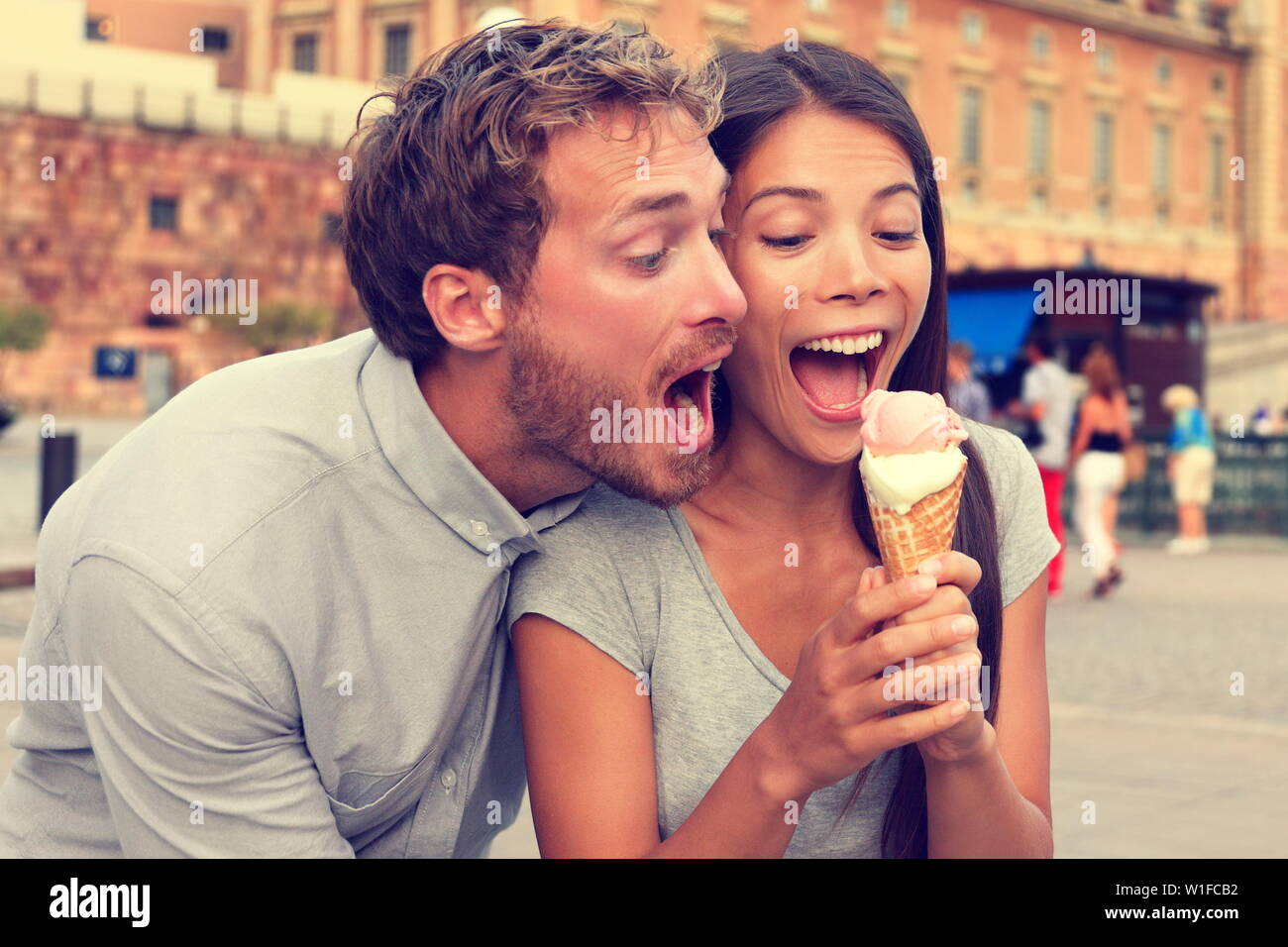 Lustig verspielt junges paar Eis essen. Goofy Portrait von Freund necken Freundin aus Beißen eines kalten Dessert in der Stadt Sommer, Stockholm, Schweden, Europa. Stockfoto