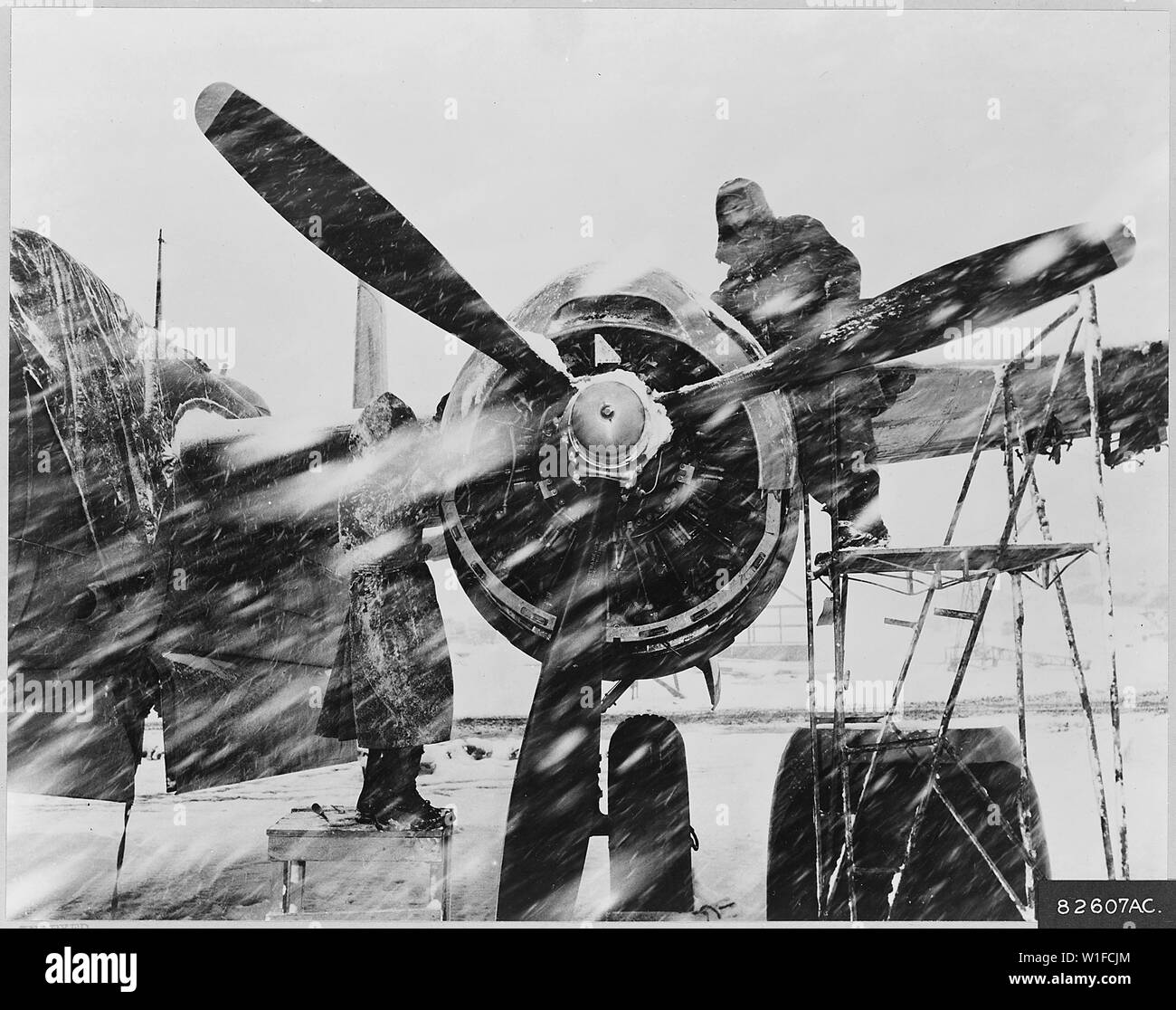 Ignorieren eines koreanischen Schneesturm, zwei Besatzungsmitglieder der 3 Bombe Flügel Arbeiten an einem Motor der US Air Force B-26 Nacht Eindringling. Diese leichten Bomber, die Durchführung der Operation Ersticken, hit kommunistischen Truppen Versorgungsleitungen jede Nacht bei jedem Wetter. Mit Tonnen von Bomben und Munition bewaffnet, angreifende durch Sichtprüfung oder Radar, die Twin engined B-26 s einen hohen Tribut von feindlichen Rolling Stock genommen seit dem 3 Bombe Flügel der Krieg im Juni 1950 eingetragen. Stockfoto