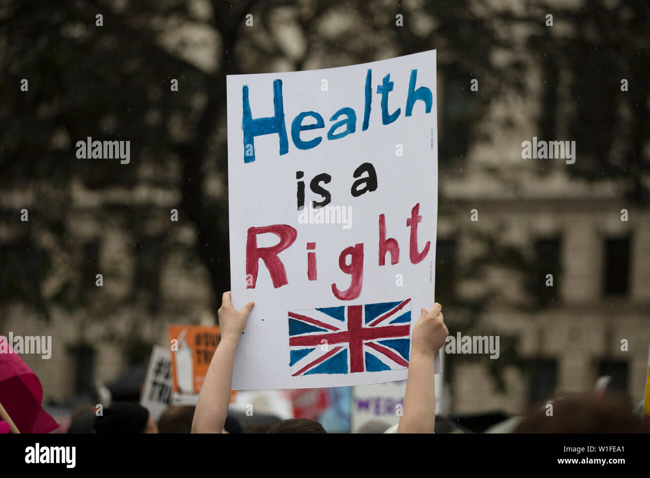 Ein Demonstrant hält eine politische Banner mit Gesundheit ist ein Menschenrecht Nachricht Stockfoto
