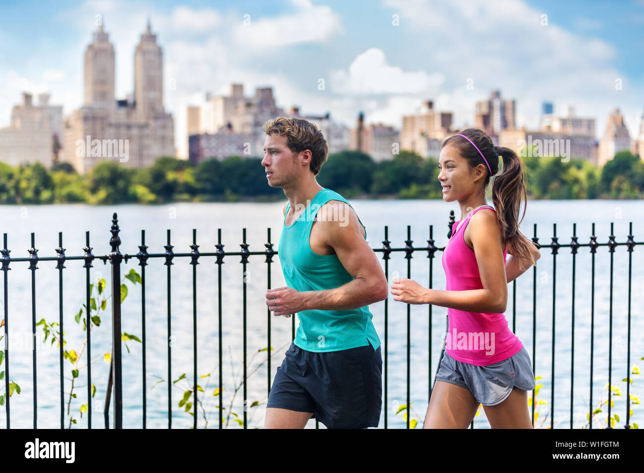 Laufen Paar Läufer beim Joggen im Central Park, New York City leben gesunde Fitness Lifestyle. Leute, Sommer Training für Marathon in Manhattan, New York. Asiatische weibliche model und Kaukasische männlichen Athleten. Stockfoto