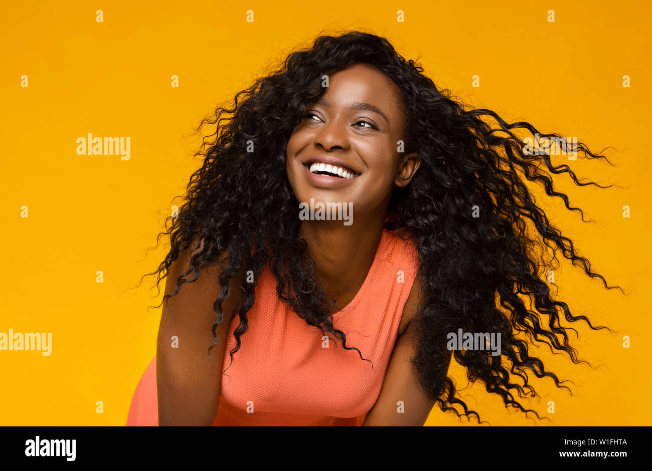 Junge afrikanische Frau lachend auf gelbem Hintergrund Stockfoto