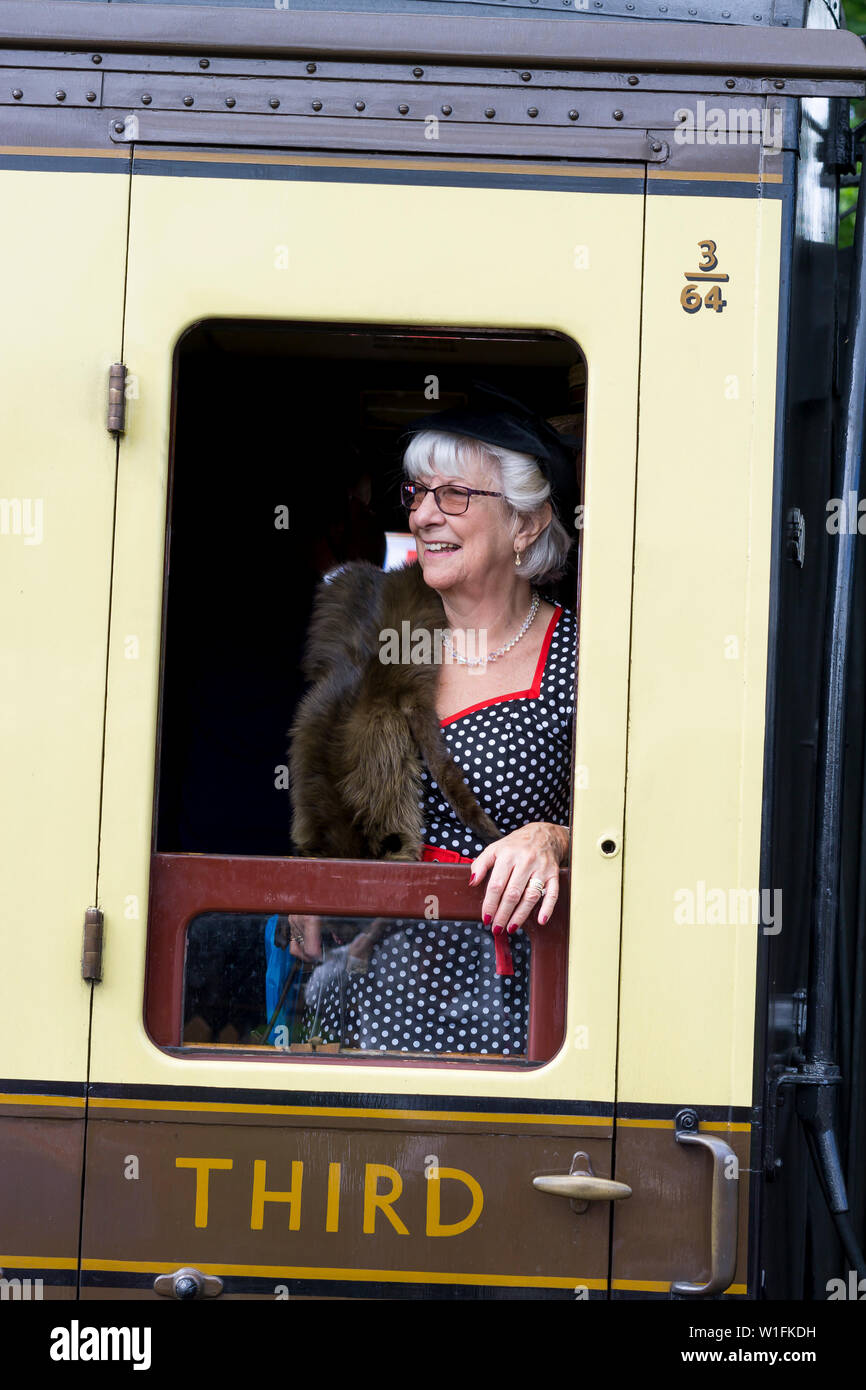 Kidderminster, Großbritannien. Juni 2019. Severn Valley Railways 'Step Back to the 40's' beginnt diesen Sommer mit einem fabelhaften Start, wobei Re-Enactors ihre Rolle spielen, um eine authentische Erholung der Kriegszeit, dem zweiten Weltkrieg Großbritanniens, zu bieten. Isolierte Frau in den vierziger Jahren lehnt sich aus dem alten Eisenbahnwagen, um aus dem Zugfenster zu schauen. Kredit: Lee Hudson Stockfoto