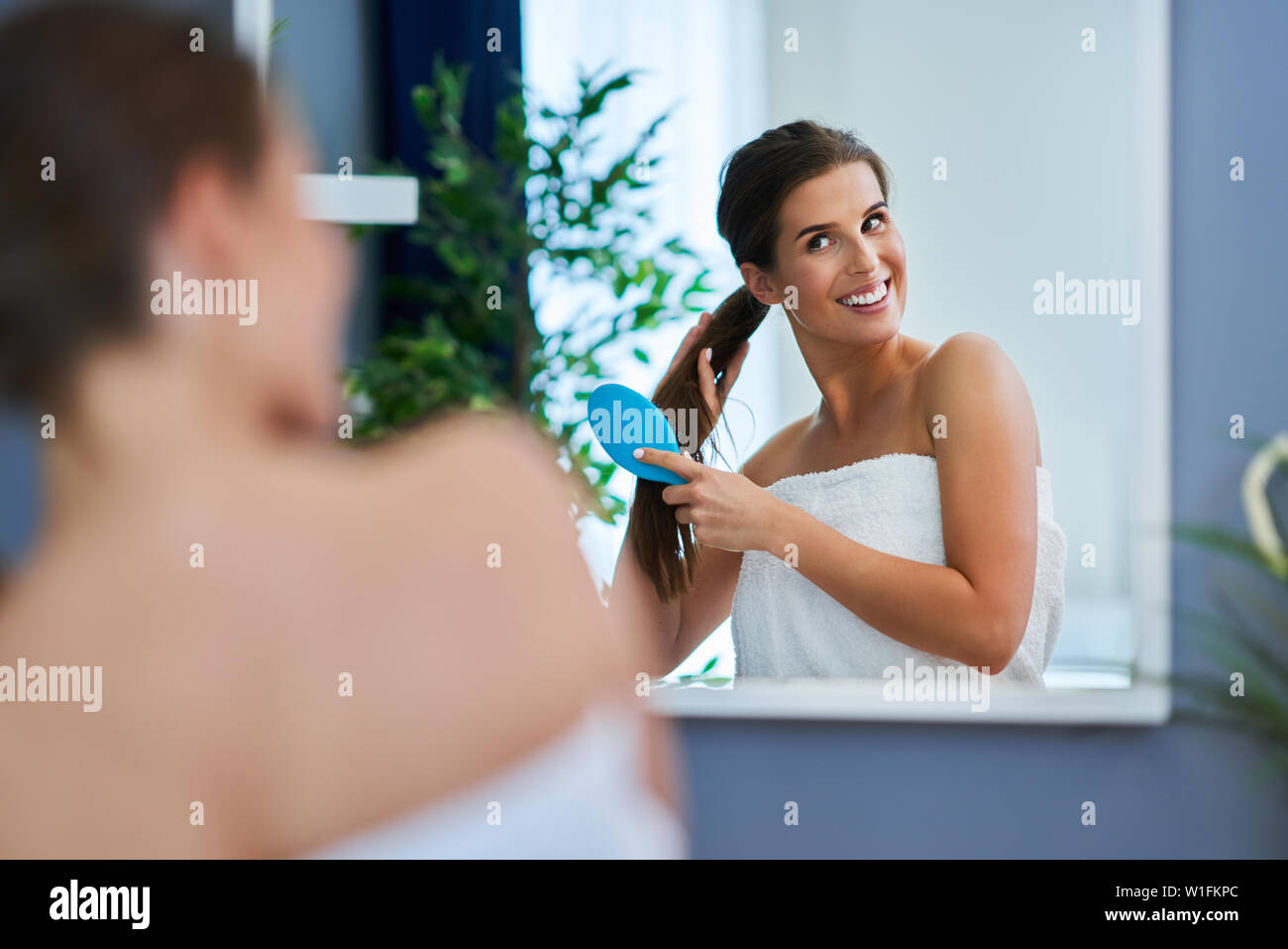 Erwachsene Frau ihre Haare bürsten in Bad Stockfoto