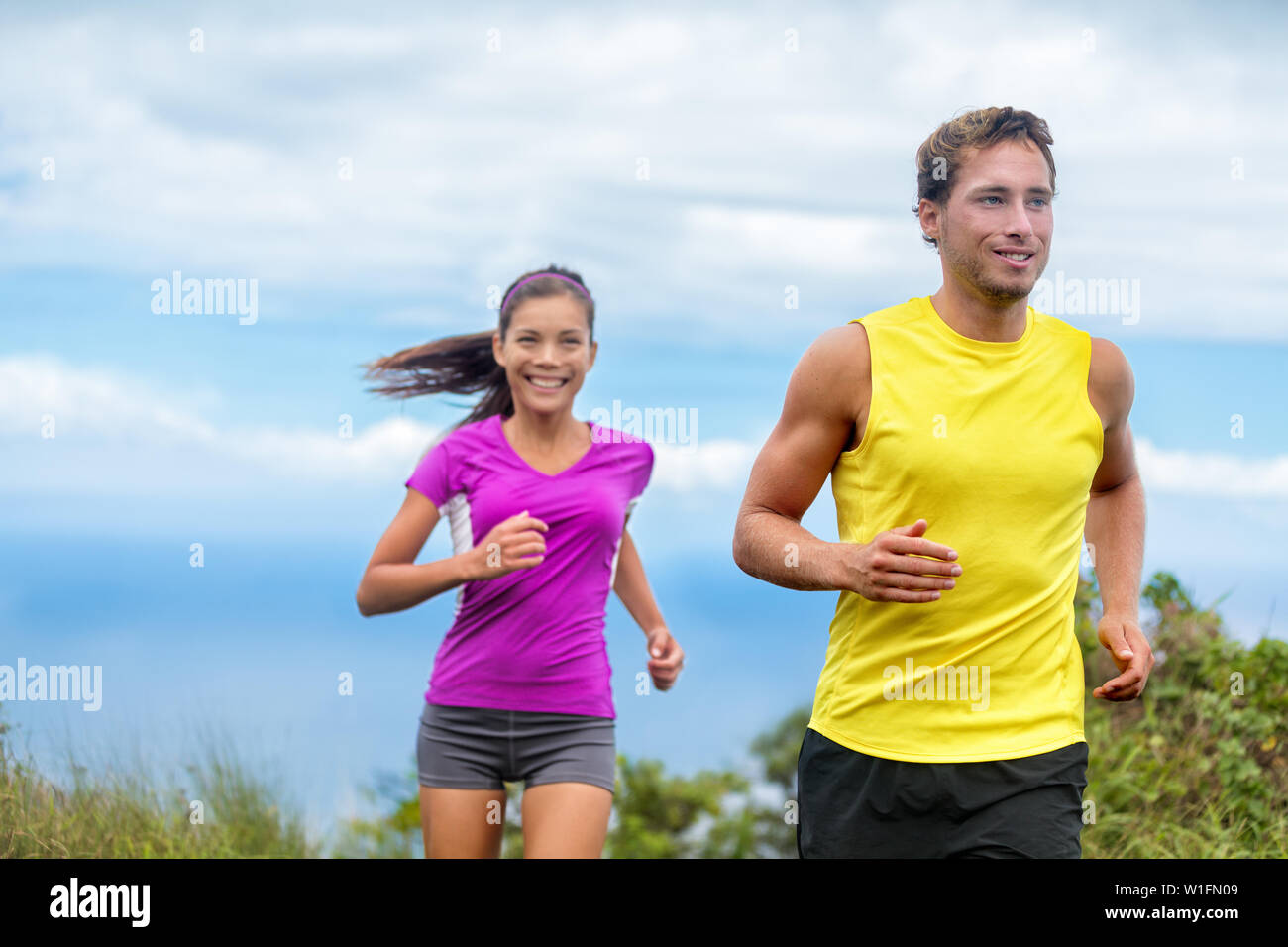 Gesunde Sportler Trail Running leben ein aktives Leben. Glücklich lifestyle Paar Athleten training cardio zusammen im Sommer im Freien. Multi-ethnischen Gruppe asiatische Frau mit den stattlichen Mann, der bereit Trainer. Stockfoto