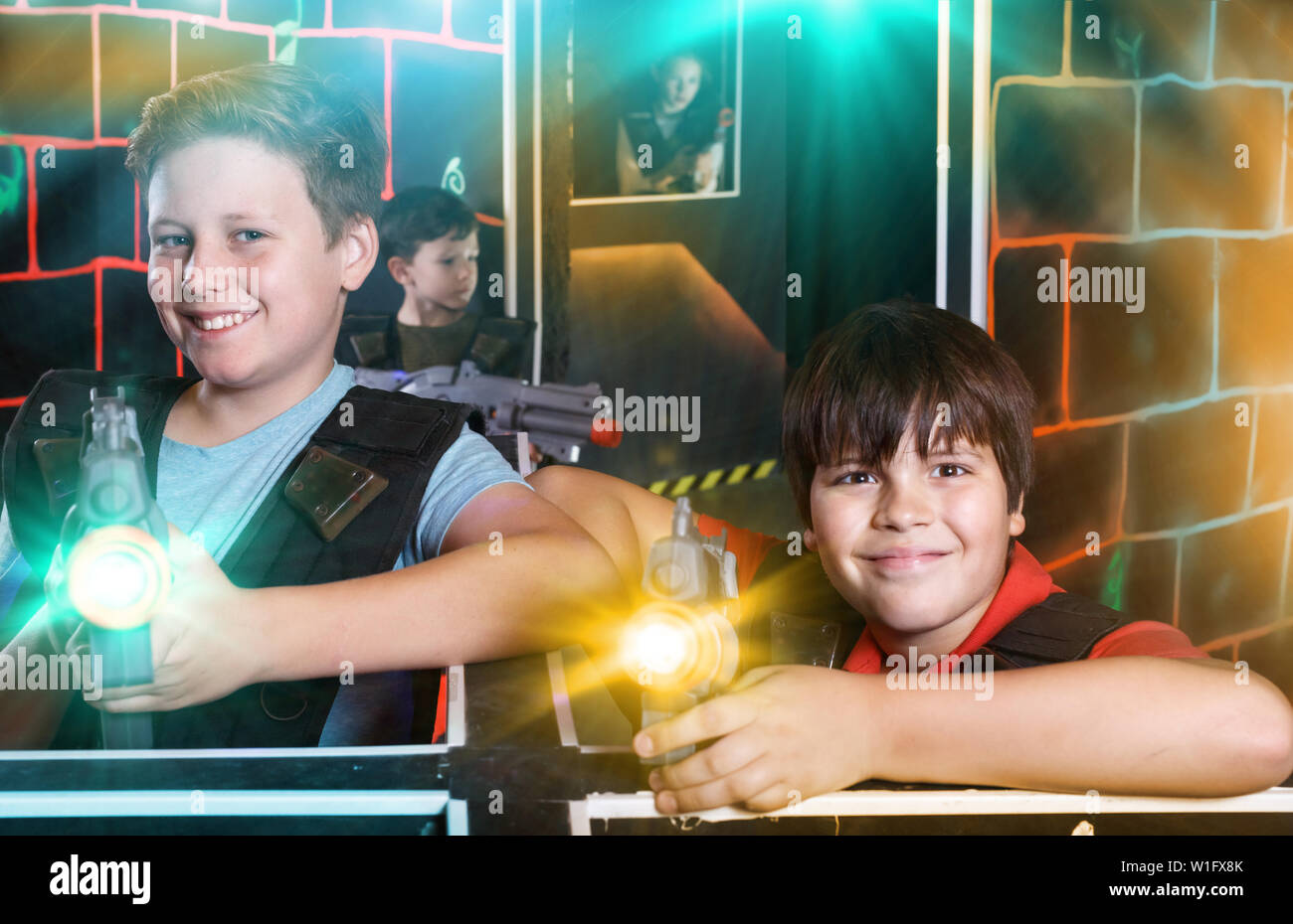 Porträt von zwei Happy Teen boys stehen mit Laserwaffen bereit für lasertag Spiel zuhause Stockfoto