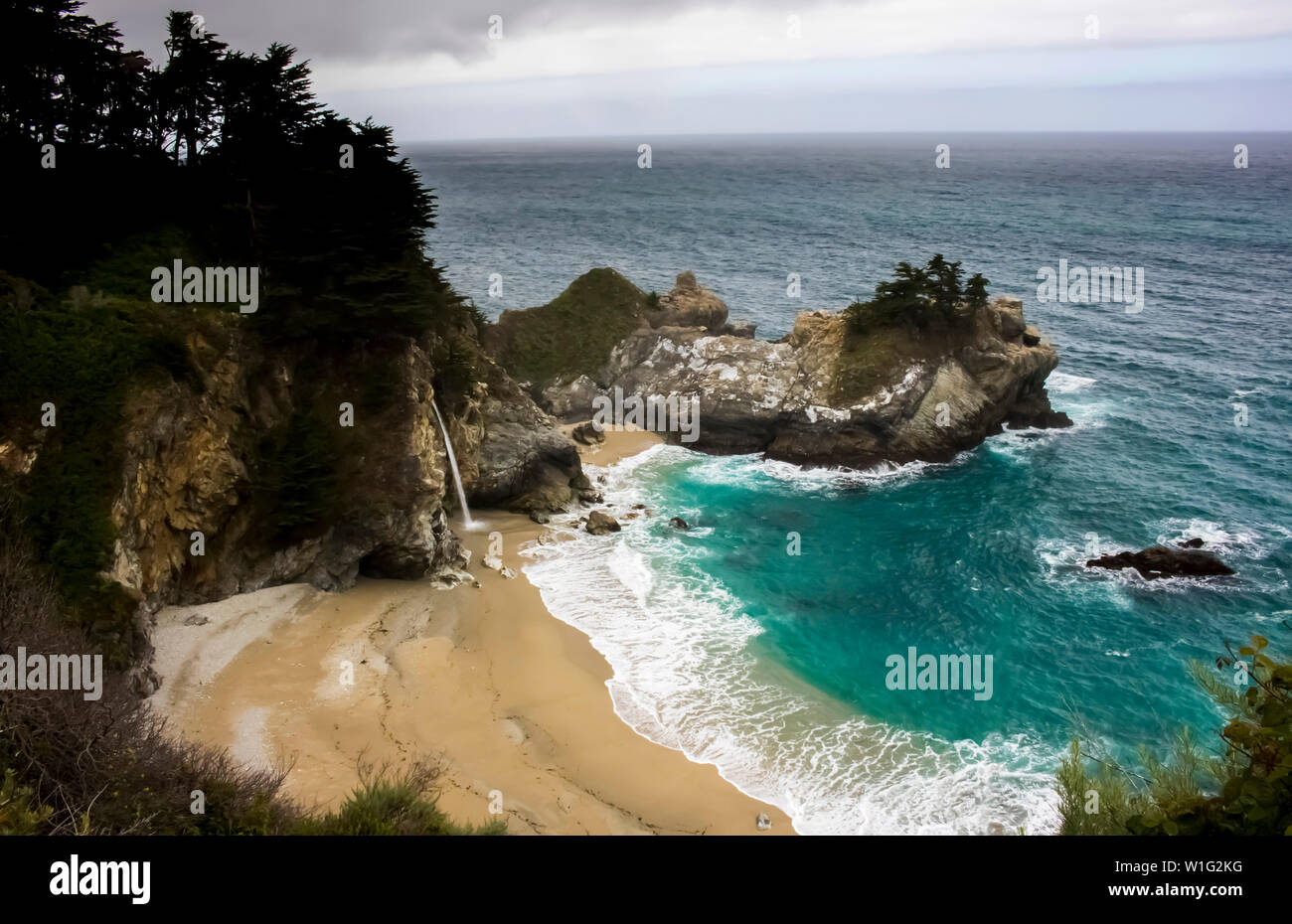 Wasserfall ergießt auf den Strand von Klippen auf der kalifornischen Küste entlang der Autobahn 1 in der Nähe von Big Sur. Stockfoto