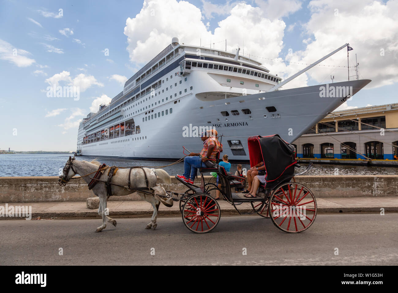 Havanna, Kuba - 19. Mai 2019: Pferdekutsche in der Altstadt von Havanna Stadt mit einem großen Kreuzfahrtschiff im Hintergrund, während Sie einen hellen und sonnigen Tag. Stockfoto