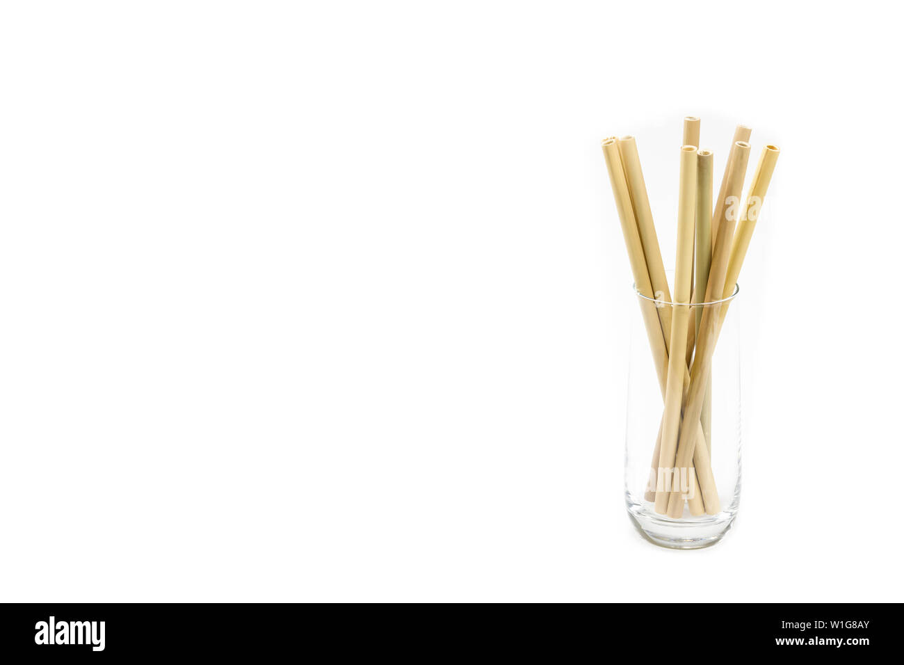 Wiederverwendbare Bambusstrohhalme in einem Glas, auf einem sauberen weißen Hintergrund. Viel Platz für individuelle Anpassungen! Stockfoto