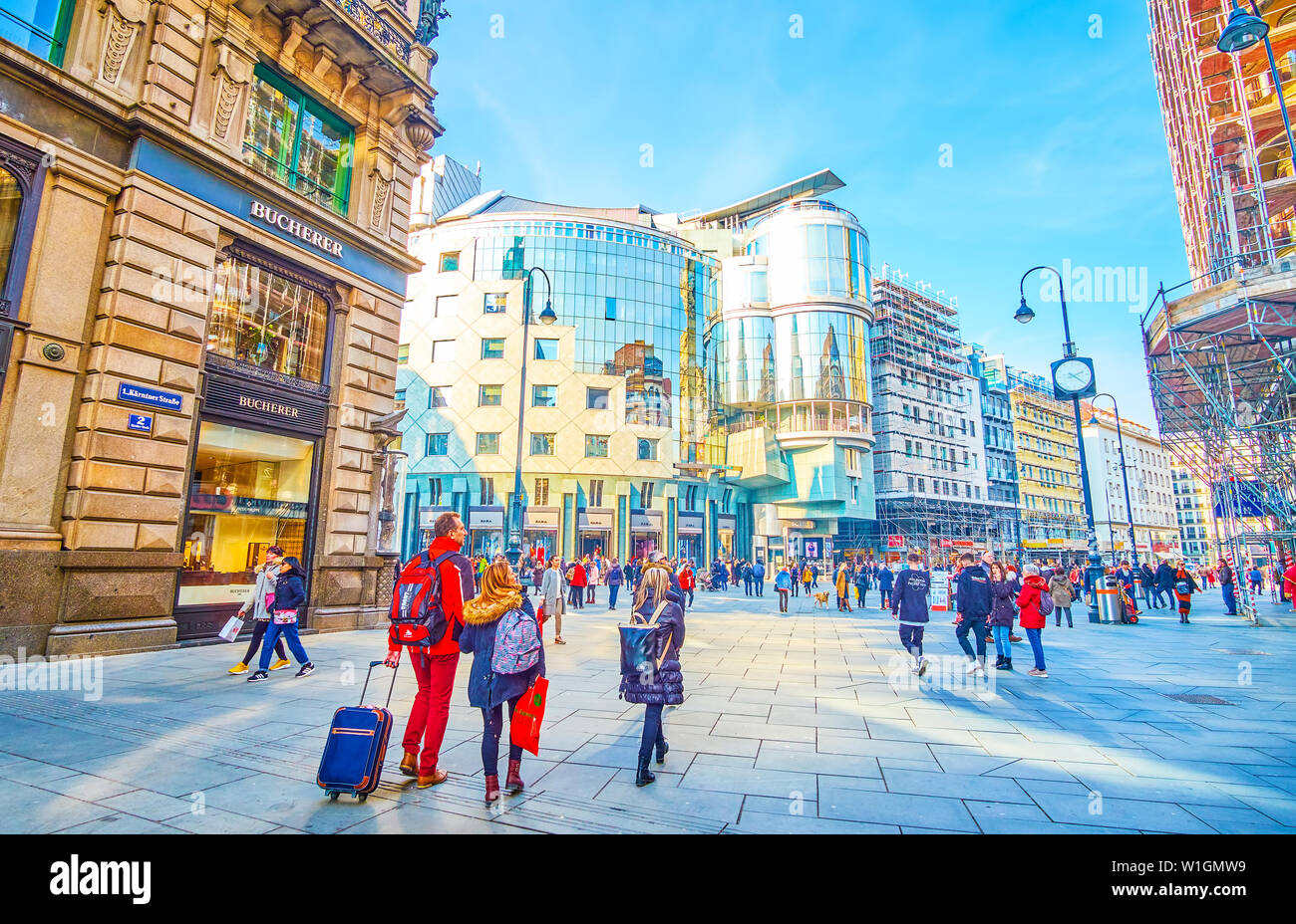 Wien, Österreich - 18. FEBRUAR 2019: Touristen zu Fuß entlang der zentralen Straßen in Wien genießen großartige Architektur der umliegenden Gebäude und Suchen Stockfoto Wien, Österreich - 18. FEBRUAR 2019: Touristen zu Fuß entlang der zentralen Straßen in Wien genießen großartige Architektur der umliegenden Gebäude und Suchen Stockfoto