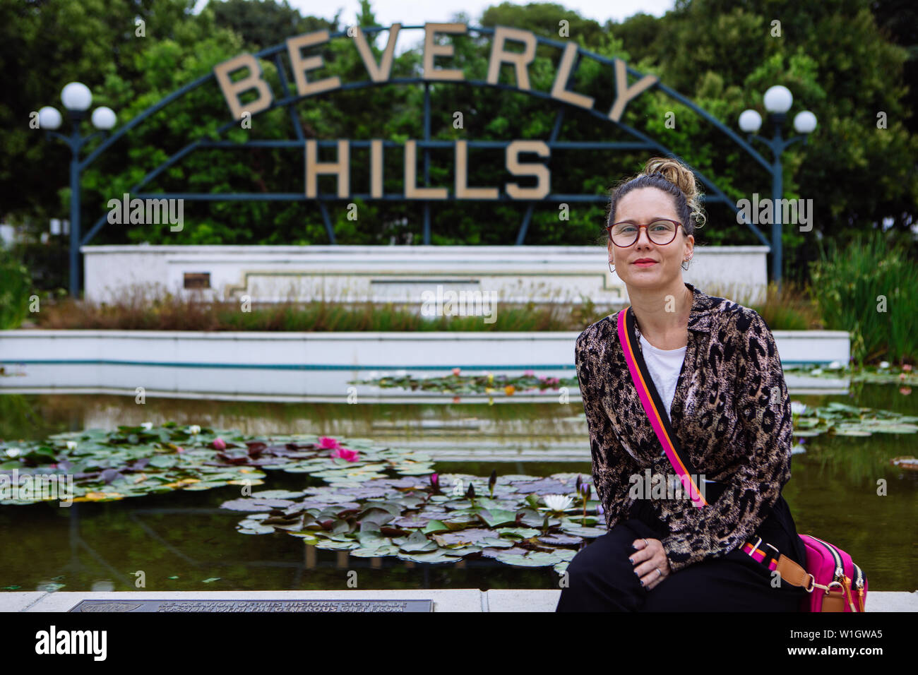 Touristische Frau in Gläsern sitzen vor von Beverly Hills, Beverly Hills, Los Angeles, Kalifornien, USA Stockfoto