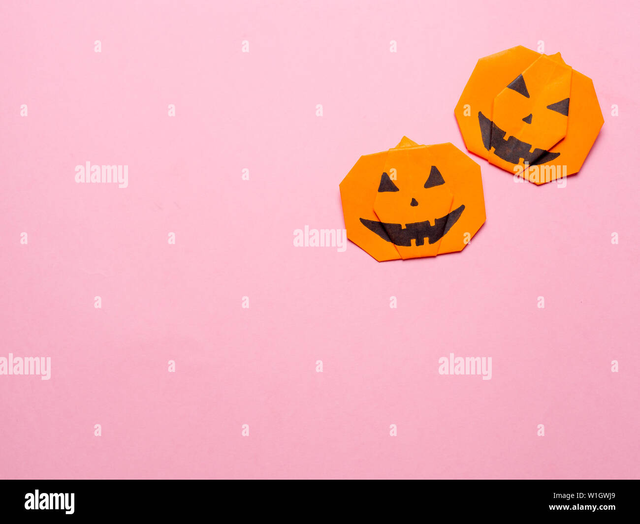 Halloween Konzept. Papier origami Kürbis auf rosa Hintergrund. Einfache Idee für Halloween - leicht gemacht Papier Kürbisse auf Trendfarbe Ceylon gelben Hintergrund. Kopieren Sie Platz für Text. Stockfoto