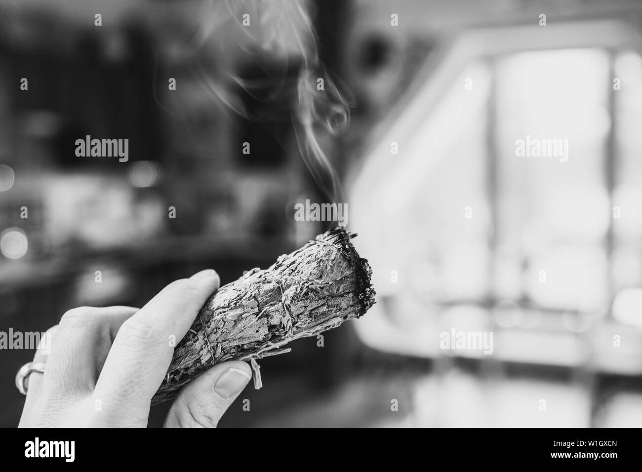 Frau hand Kraut Bündel getrockneter Salbei smudge Stick rauchen. Es wird geglaubt, negative Energie zu reinigen und Wohnräume in Zimmer reinigen Stockfoto