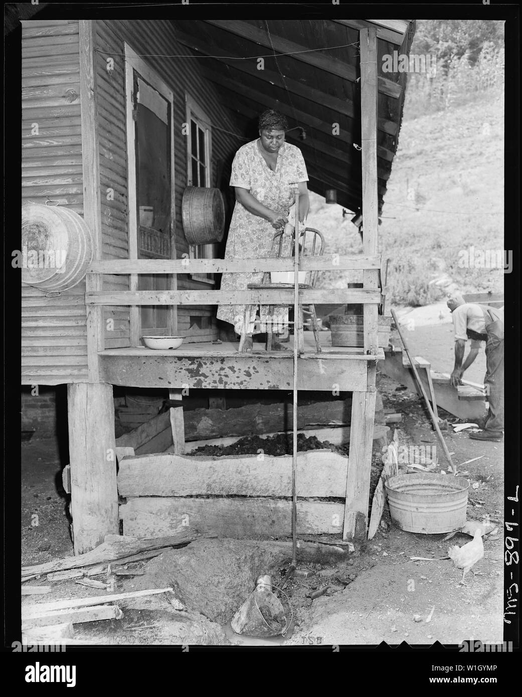Frau Butler Phillips, Ehefrau von Bergmann, ein Huhn auf der Rückseite proch von ihrem Haus in Unternehmen. Adams, Rowe & Norman Inc., Porter Mine, Adamsville, Jefferson County, Alabama. Stockfoto