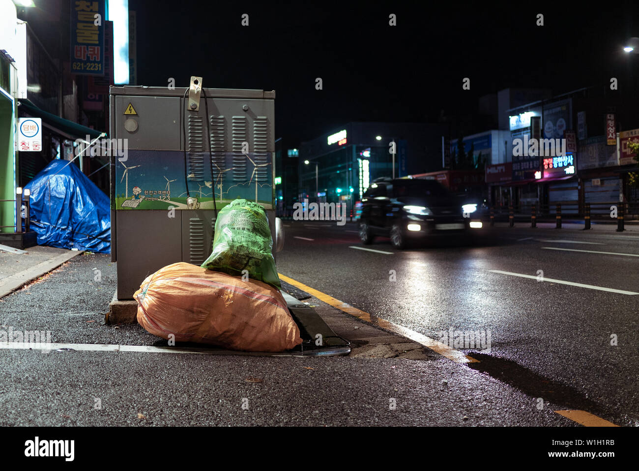 Seoul, Südkorea - 30.10.18: Säcke mit Müll liegen auf der Seite der Straße bei Nacht. Ein Haufen Müll auf die Straße geworfen. Neonlicht. Umwelt p Stockfoto