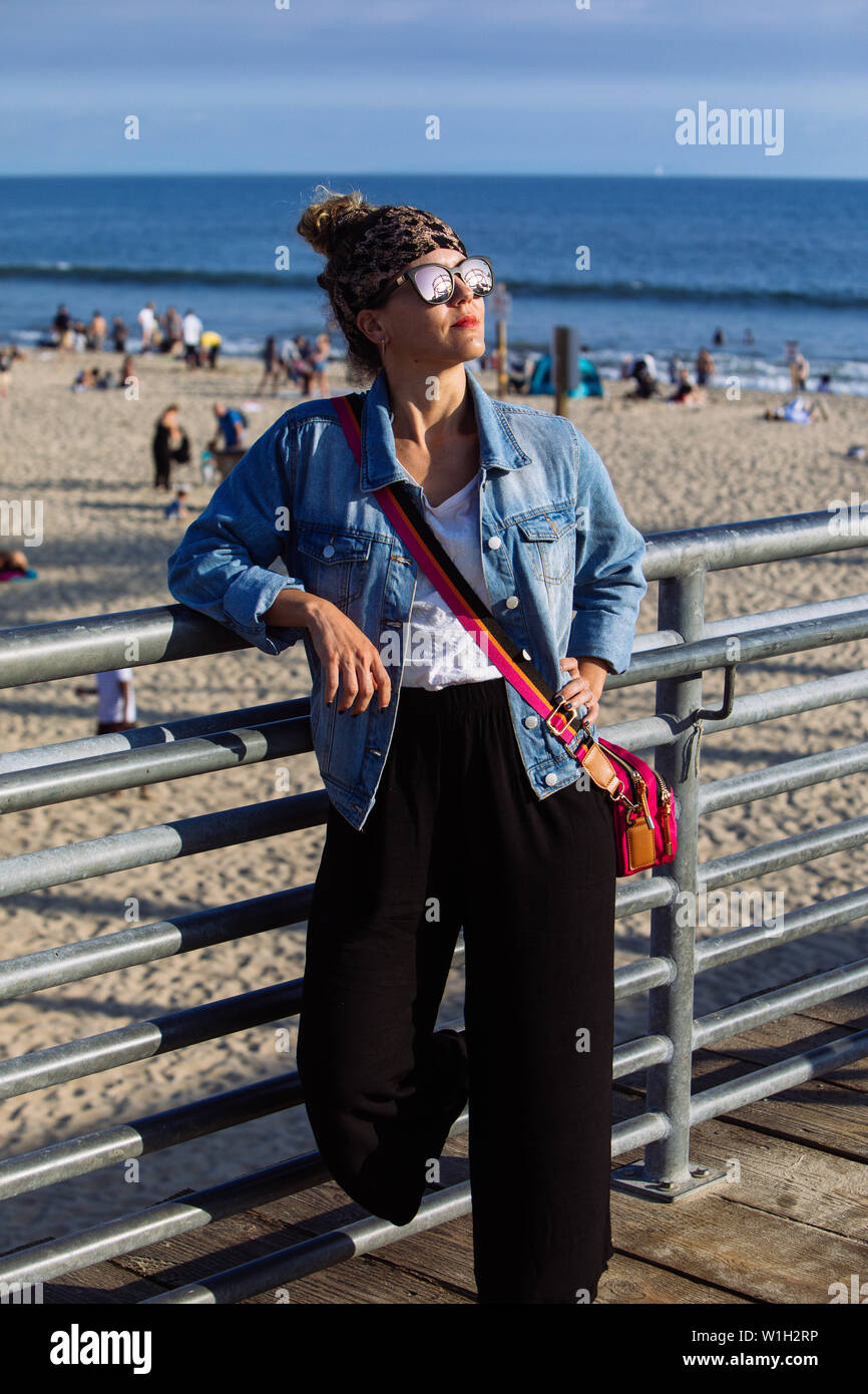 Frau mittleren Alters mit Schattierungen in Santa Monica Beach, Los Angeles, Kalifornien posing Stockfoto