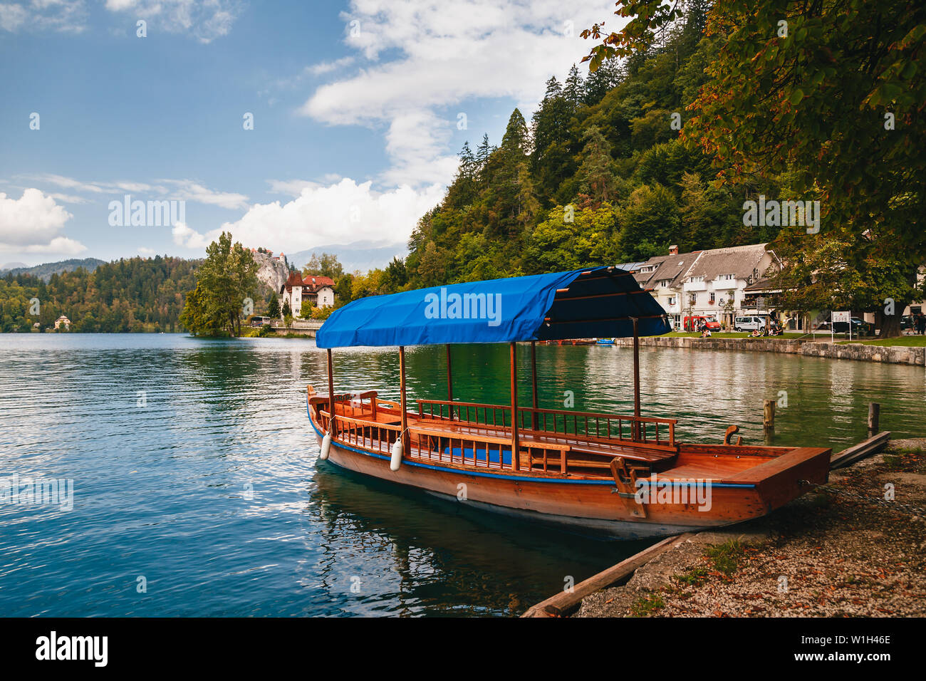 Bled, Slowenien - September 8, 2018: Blick auf die reine Bleder See mit einem traditionellen Pletna für Touristen, das herrliche Schloss Fels mit dem Bled Stockfoto