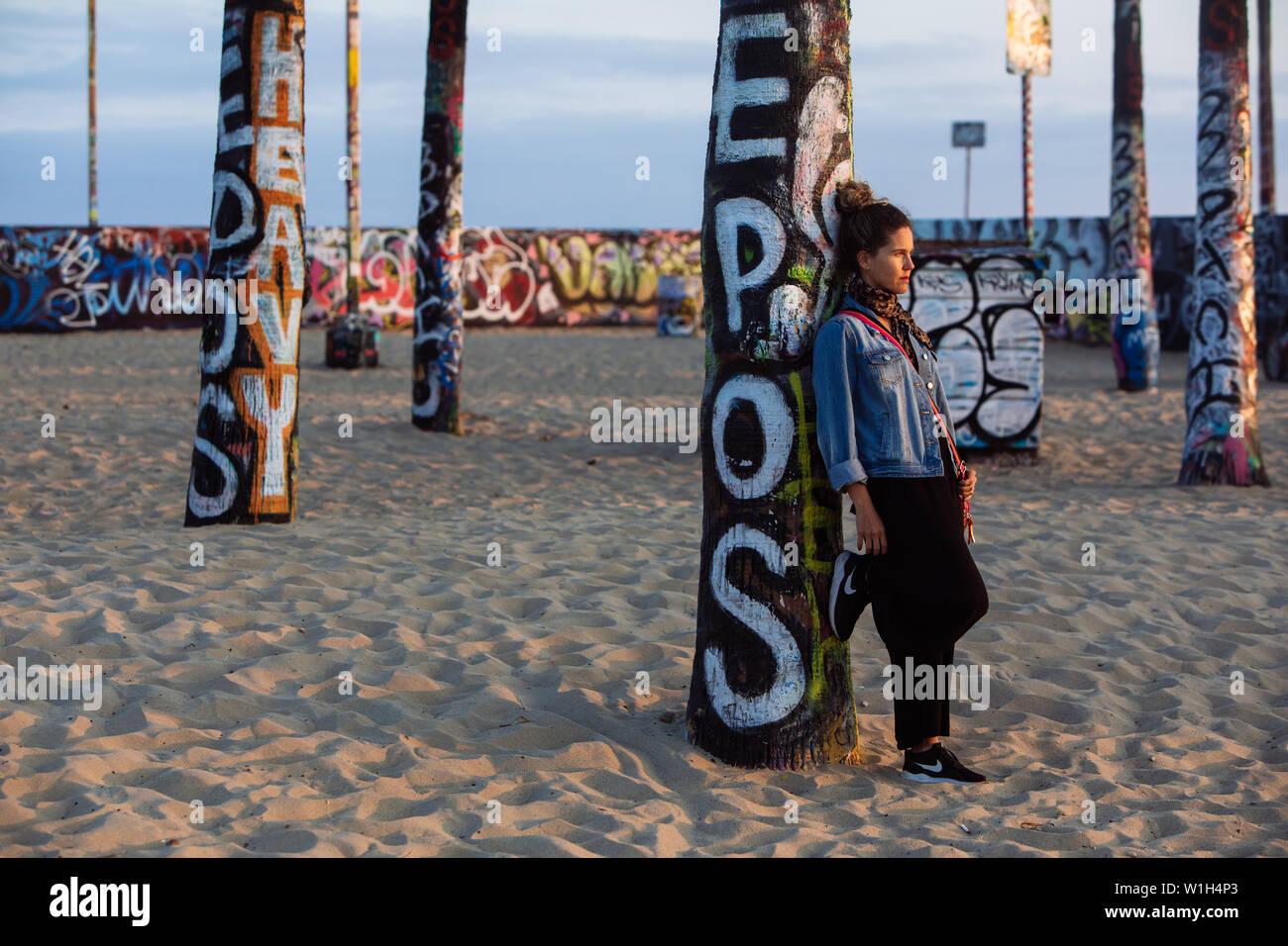 Frau mittleren Alters auf ein Graffiti Palme in Venice Beach, Los Angeles, Kalifornien, USA, lehnte sich Stockfoto