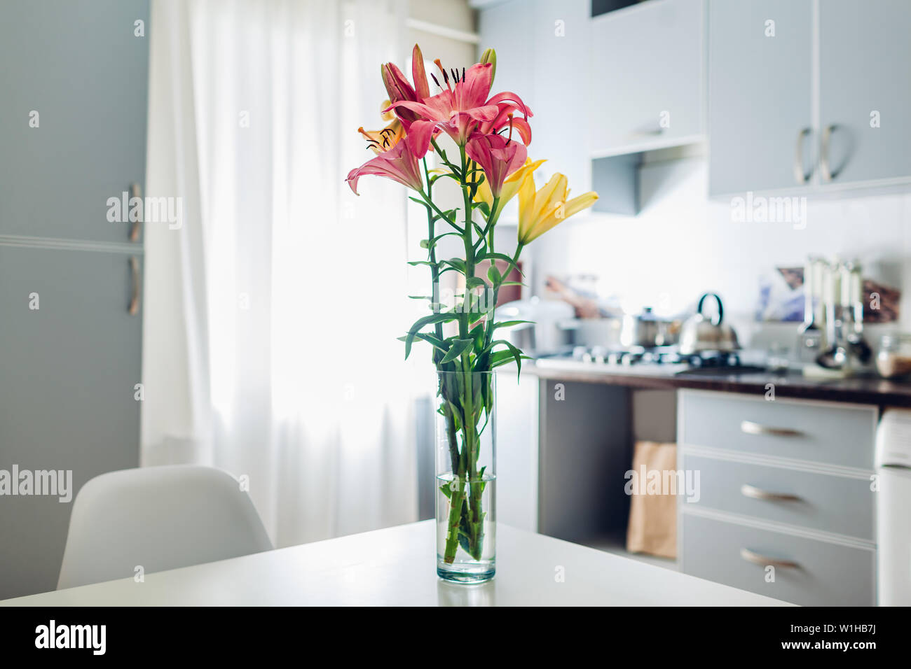 Bunte Lilien. Moderne Küche Design. Innenraum weiss und silber Küche mit Strauß mit frischen Blumen geschmückt. Stockfoto