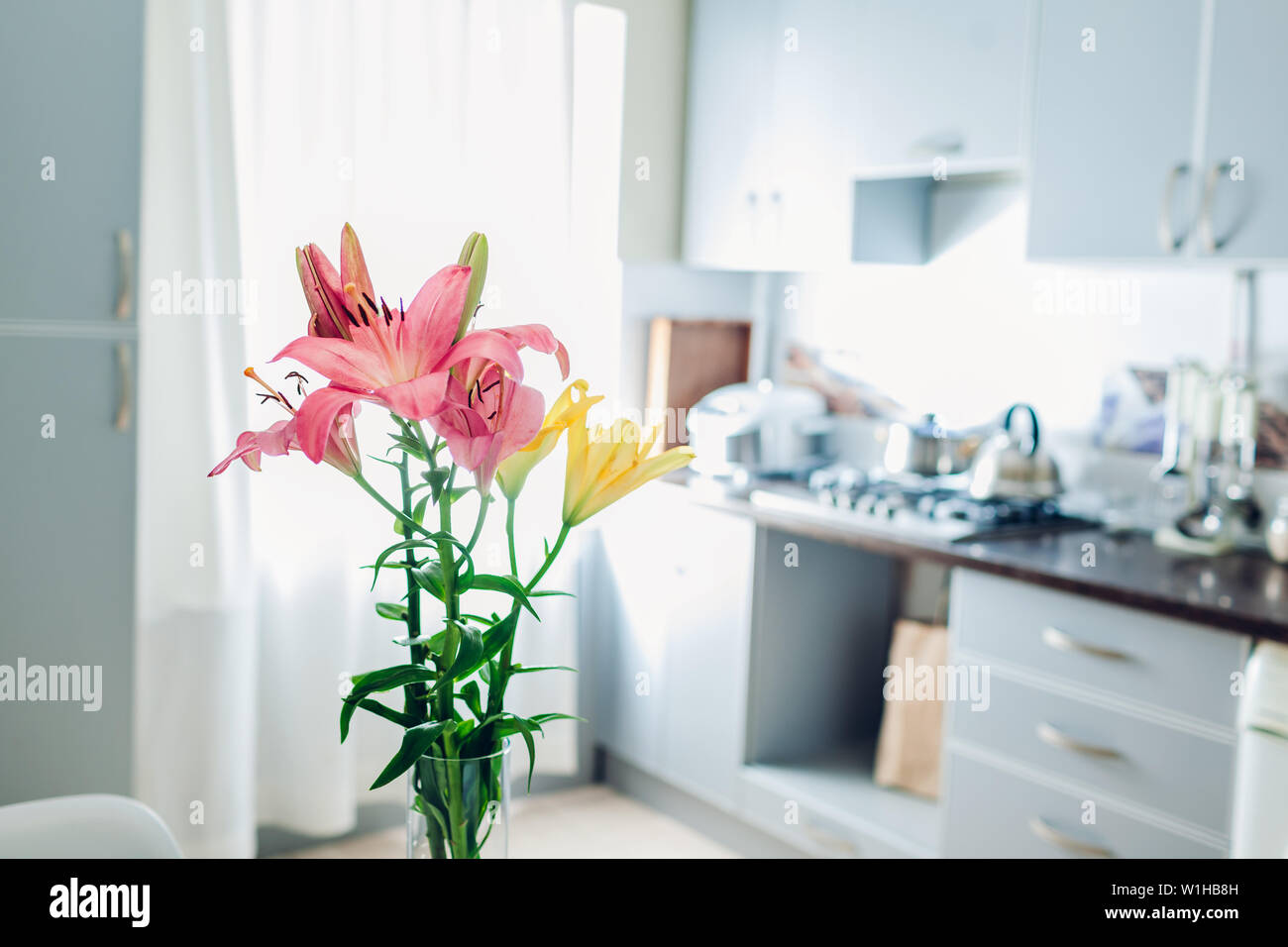 Bunte Lilien. Moderne Küche Design. Innenraum weiss und silber Küche mit Strauß mit frischen Blumen geschmückt. Stockfoto