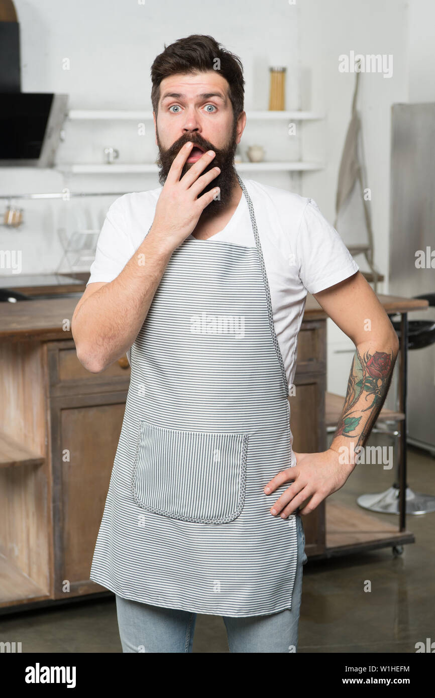 Völlig ratlos. Überrascht kochen für den offenen Mund mit der Hand. Der bärtige Mann, der Koch Schürze in der Küche. Koch an seinem Arbeitsplatz. Etwas Besonderes zu kochen. Stockfoto