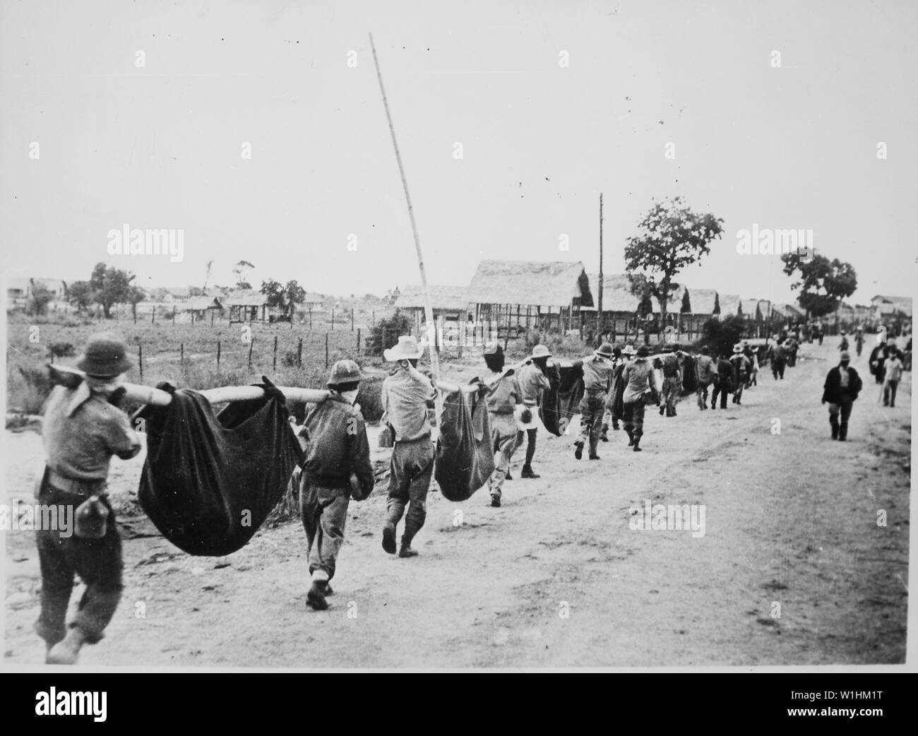 Foto von amerikanischen Gefangenen mit improvisierten Würfe zu tragen Kameraden, 05/1942; Umfang und Inhalt: Original Bildunterschrift: Dieses Bild, von den Japanern gefangengenommen, zeigt amerikanische Gefangene mit improvisierten Würfe zu tragen, die ihrer Kameraden, die aus dem Mangel an Nahrung oder Wasser marsch von Bataan, entlang der Straße fiel. Philippinen, Mai 1942. Allgemeine Hinweise: Laut Oberst Melvin H. Rosen (U.S. Armee im Ruhestand), dieses Bild ist keine Fotografie während der bataan Tod März genommen, sondern ein Foto von einer Beerdigung Detail am Lager O'Donnell, der Endstation der Tod März. Herr Ros Stockfoto