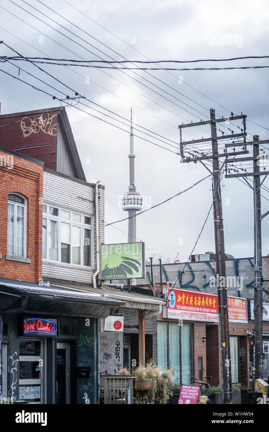 TORONTO, KANADA - 14. NOVEMBER 2018: Typische Kensington Market Street mit dem CN Tower im Hintergrund. Kensington Market ist ein Hipster in nach unten Stockfoto