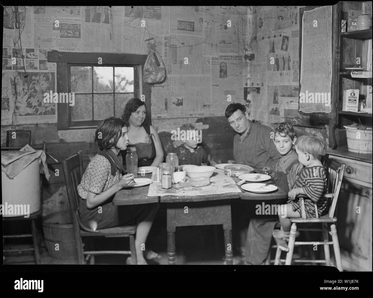 Scott's Run, West Virginia. Die Beschäftigten miner Familie - Sessa Hill - Dieses Bild wurde bei der natürlichen Abendmahl Stunde berücksichtigt. Der Mann ist ein Bergwerk, Mechaniker, alle Arten von Maschinen installiert. Zuerst weigerte er sich, um fotografiert zu werden und fluchte uns und die Regierung und die Kohle als Betreiber von seinem minery unterhalten zu werden. Wenn wir zu ihm sprach, zeigte er uns sechs Aussagen, die er in fünf verschiedenen Bankrott Minen auf Scott's Run statt. Er hatte nicht seinen letzten Zahlen in jeder Konkurs, der bezahlt. Stockfoto