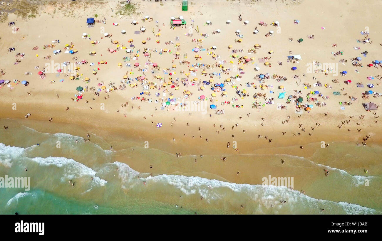 Überfüllten, öffentlichen Strand mit bunten Sonnenschirmen, Luftbild. Stockfoto