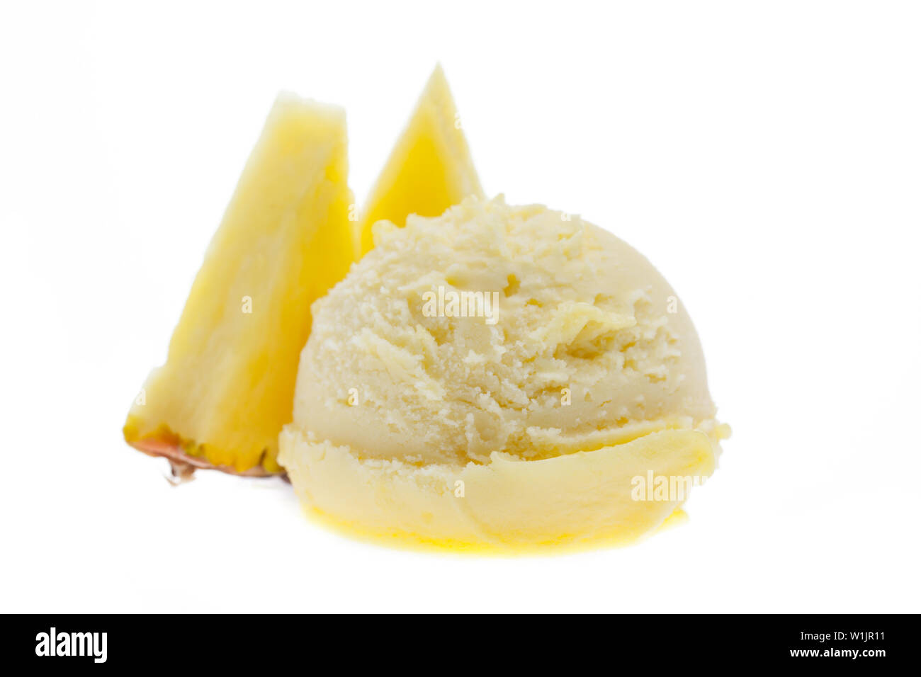 Eine Kugel Eis mit Ananas Stücke Ananas von vorne Seitenansicht auf weißem Hintergrund Stockfoto