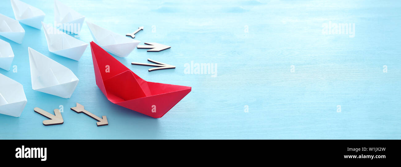 Business. Führung Konzept Bild mit Papier Boote auf Blau Holz- Hintergrund. Ein Führer Führung othes. Stockfoto