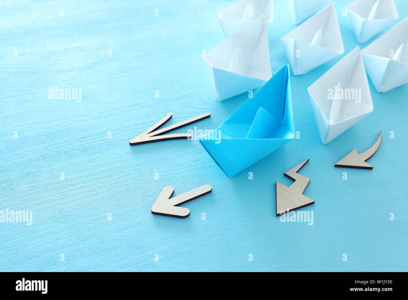 Business. Führung Konzept Bild mit Papier Boote auf Blau Holz- Hintergrund. Ein Führer Führung othes. Stockfoto
