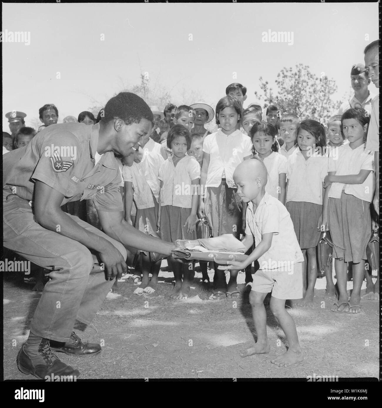 United States Air Force Staff Sergeant Richard Rolle der 41 taktischen Elektronische Kriegsführung Squadron gibt eine Schule Paket zu einem der Kinder im Wat Nong Ta t Schule in Chainat Thailand. Die 41. und 42. TEWS bestanden aus 387 Pakete an fünf Schulen. Stockfoto