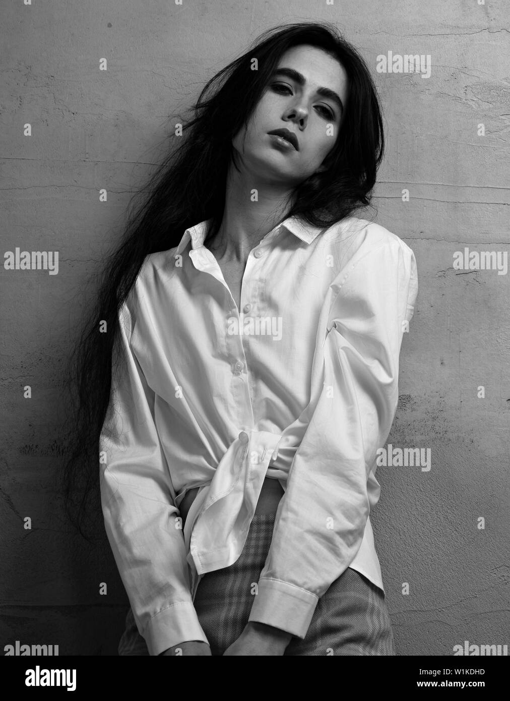 Traurig Depression young woman in Red Rock und weißes Hemd auf graue Wand studio Hintergrund posiert. Portrait von natürlichen Ausdruck Gesicht. Nahaufnahme. Stockfoto
