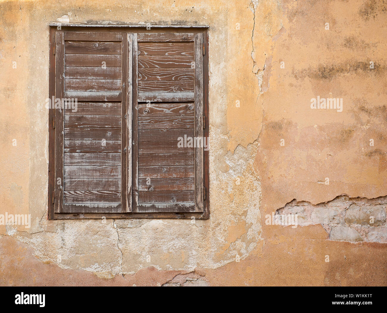Fenster und Wand. Ein Fenster mit Fensterläden steht aus einer alten Mauer in der Gemeinde Piran, Slowenien. (C) 2017 Tom Kelly Stockfoto