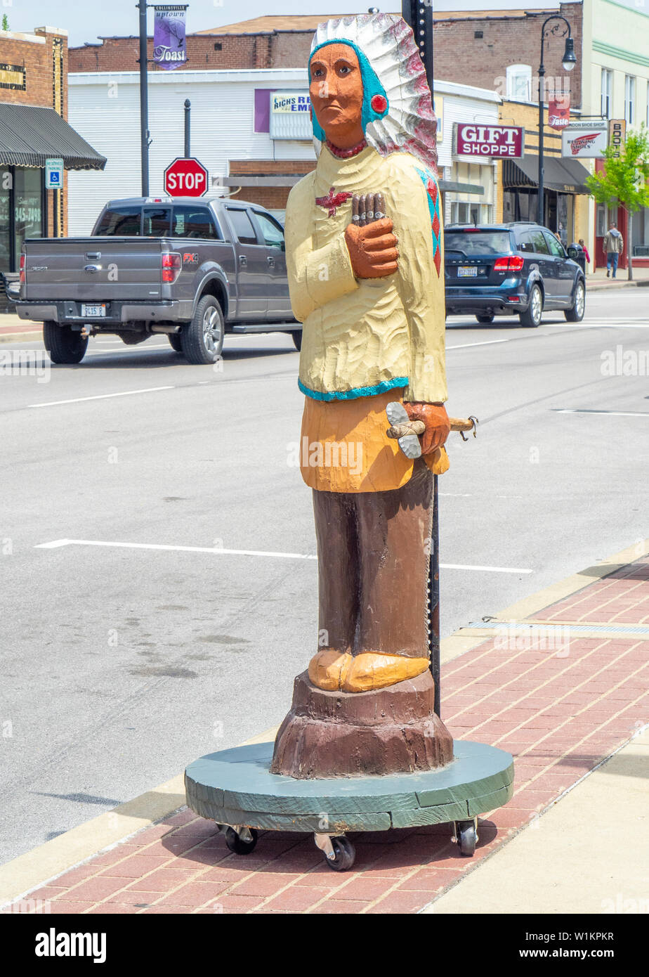Geschnitzte hölzerne Indianer Mann hält gigars auf Hauptstraße Collinsville Illinois USA. Stockfoto
