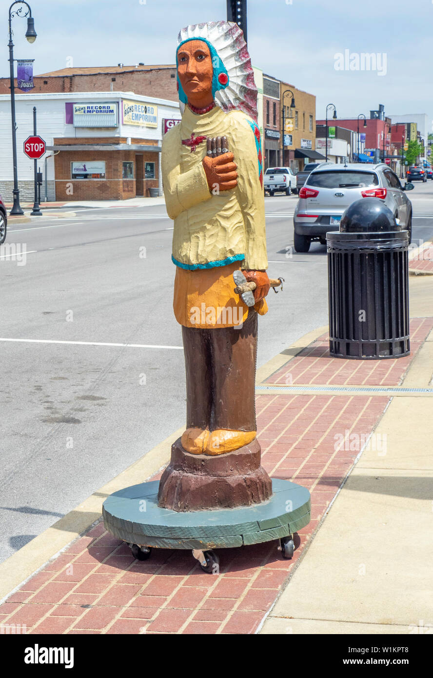 Geschnitzte hölzerne Indianer Mann hält gigars auf Hauptstraße Collinsville Illinois USA. Stockfoto