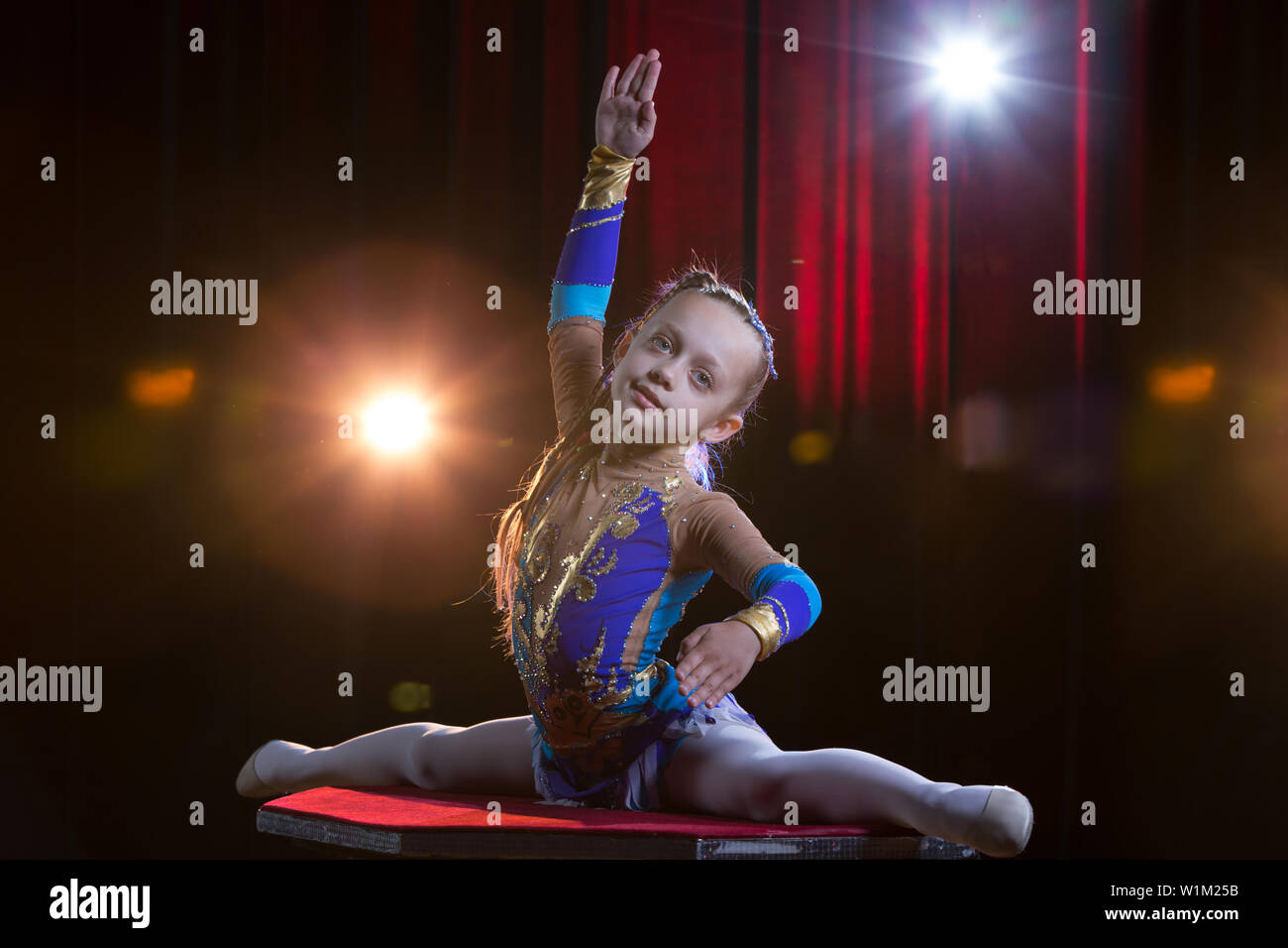 Ein Mädchen mit einem flexiblen Körper. Führt einen Zirkus Künstler. Zirkus Gymnast. Balanceakt. Das Kind führt eine akrobatische Tricks Stockfoto