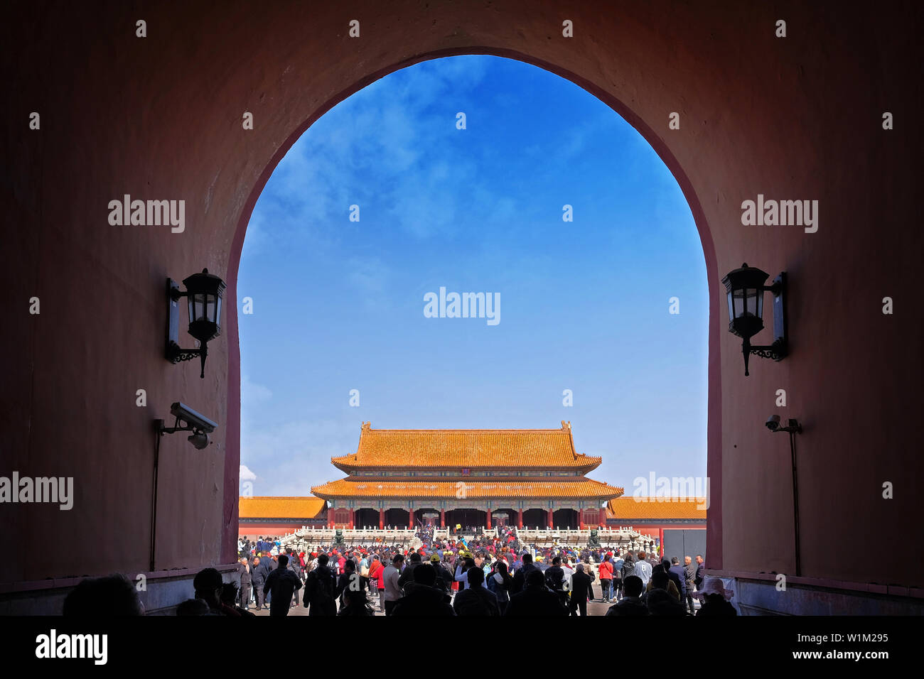Menschen, die durch eine der internen rot gefärbten Tore des Palastes Museum, wie die Verbotene Stadt in Peking bekannt, auf dem Weg zu einem Gebäude mit einem Stockfoto
