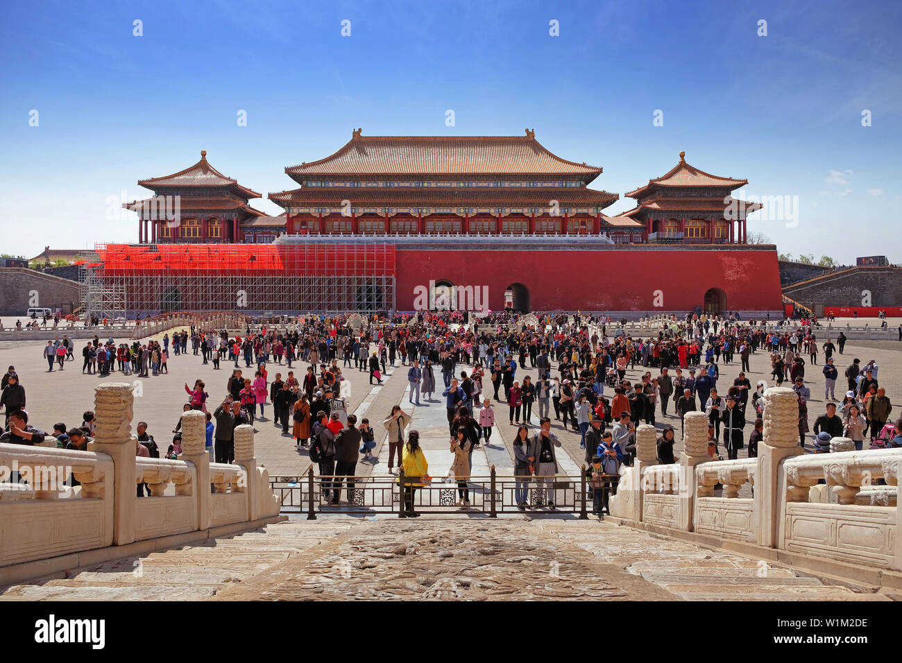 Marmor Muster vor einem überfüllten Platz im Inneren des Palastes Museum in Peking, die auch als die "Verbotene Stadt" bekannt, mit Blick auf ein rotes Tor mit einem braunen Dach Stockfoto