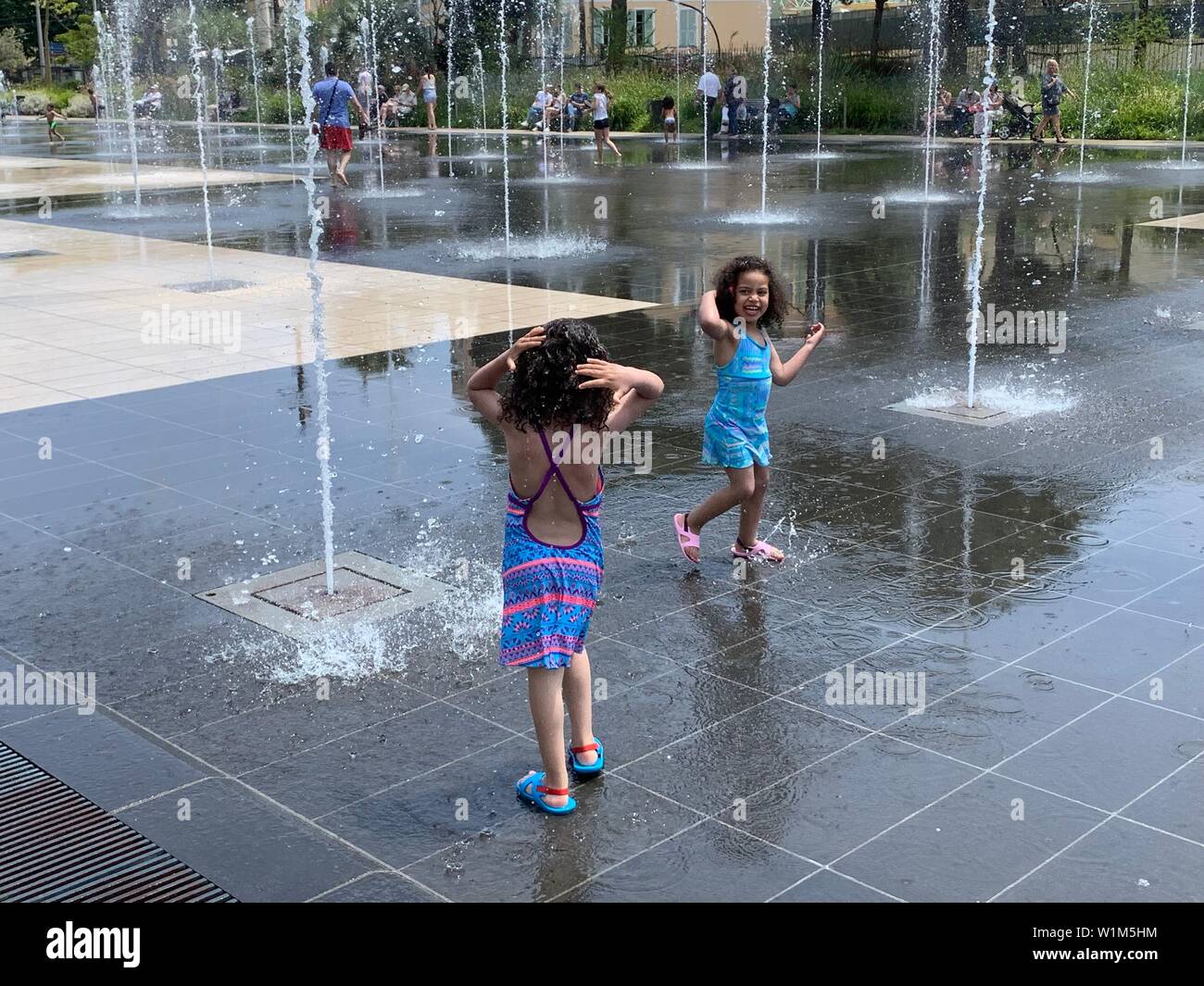 Nizza, Frankreich - Juni 8, 2019: Kleine Mädchen beim Spielen im Brunnen in Espace Massena in Nizza Stockfoto