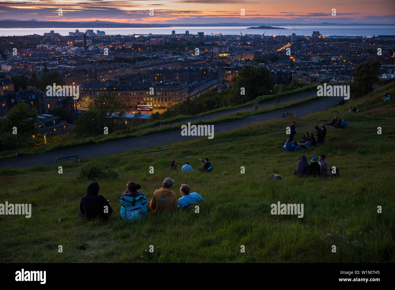 Picknicken beobachten Sie den Sonnenuntergang vom Calton Hill, ein UNESCO-Weltkulturerbe in Edinburgh, Schottland. Stockfoto
