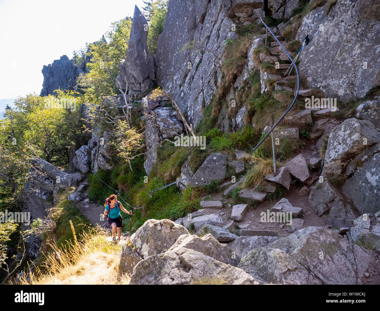 Frauen Klettern bis auf schmalen Felsen in den Vogesen im Elsass am Lac Blanc, Frankreich Stockfoto