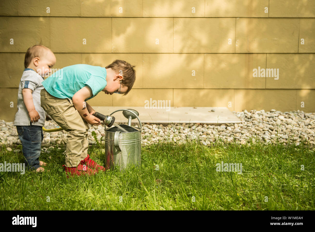 Zwei kleine Jungen im Garten füllen Gießkanne Stockfoto