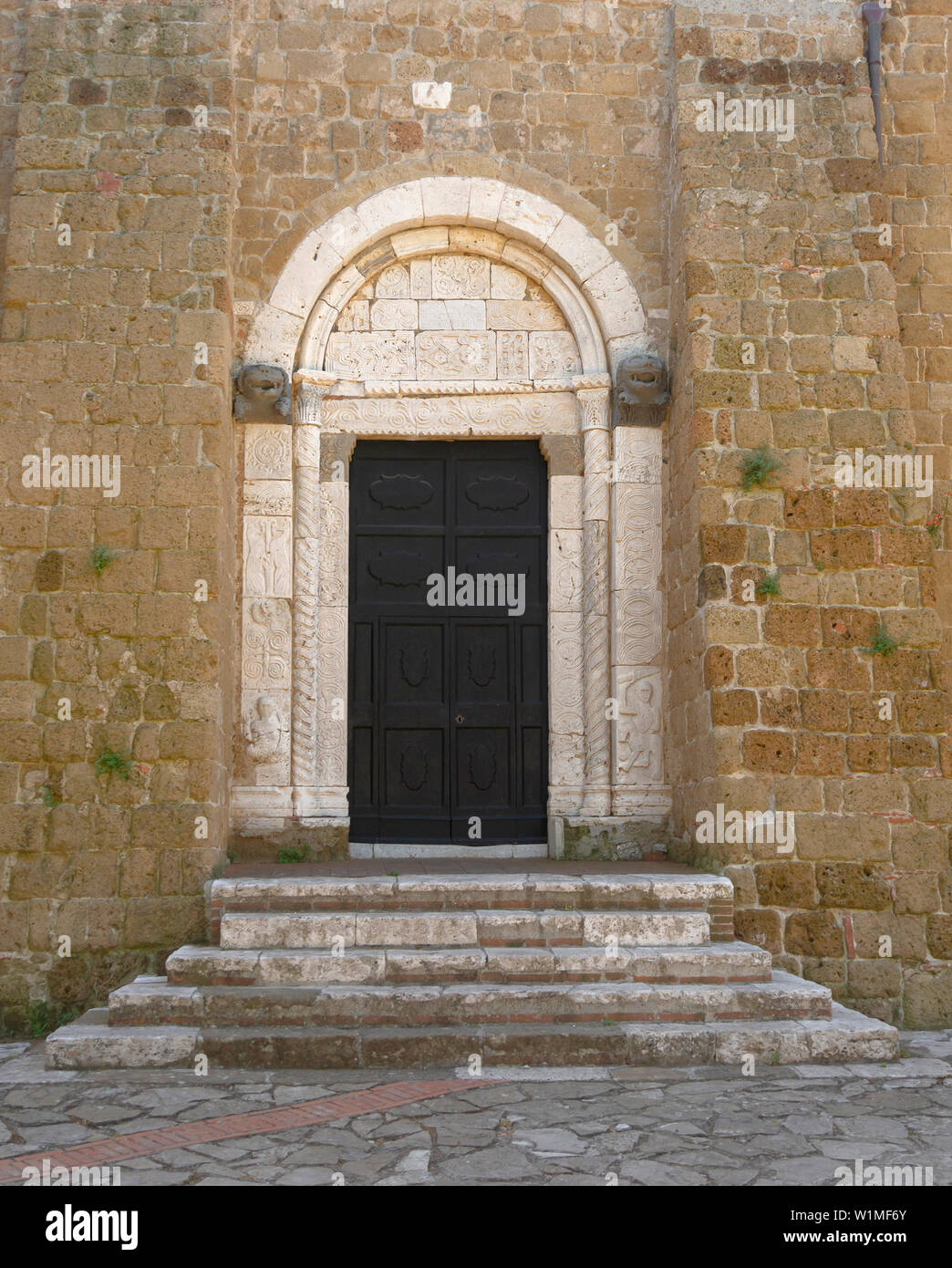 SOVANA, Toskana, Italien - 16. JUNI 2019 - Eingang zur Concattedrale dei Santi Pietro e Paolo aka Dom von Sovana, mit alten Schnitzereien. Stockfoto