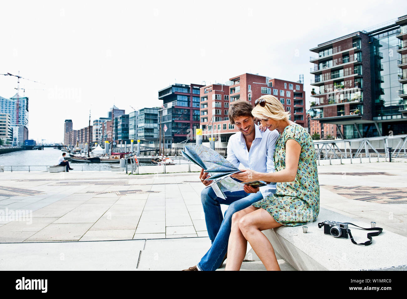 Paar lesen einen Stadtplan an Magellan-Terraces, HafenCity, Hamburg, Deutschland Stockfoto