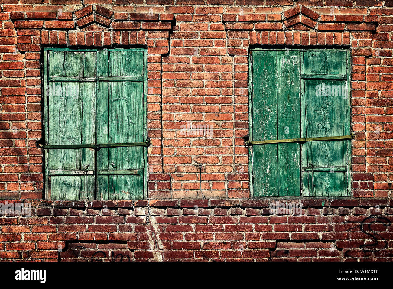 Alte Fenster mit geschlossenen Fensterläden auf eine Mauer aus Stein Stockfoto